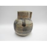 A Studio pottery jug decorated with lined geometric patterns. Indistinctly signed to base, 22.5cm