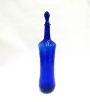 A dark blue studio glass stoppered bottle, 58cm tall