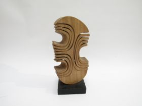 JOHN SPIELMAN (b.1944) A carved wooden abstract sculpture on ebonised base. Stamped mark. 28cm high
