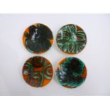 Four Poole Delphis pin dishes in orange, green and black colourways, black back stamps to three, one