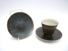 DAME LUCIE RIE (1902-1995) (ARR) A coffee cup and saucer in Manganese glaze, sgraffito lines to