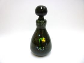 A William Manson for Manart glass bottle and stopper in mottled green with flower and cane detail.