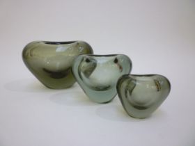 Three Per Lutken Holmegaard heart vases in smoked glass and of graduating sizes. Incised marks to