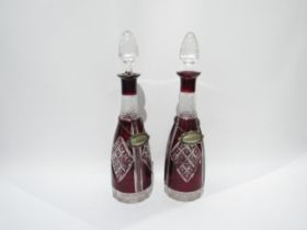 A pair of Bohemian ruby cut glass decanters, with gin and whisky labels, 37.5cm high