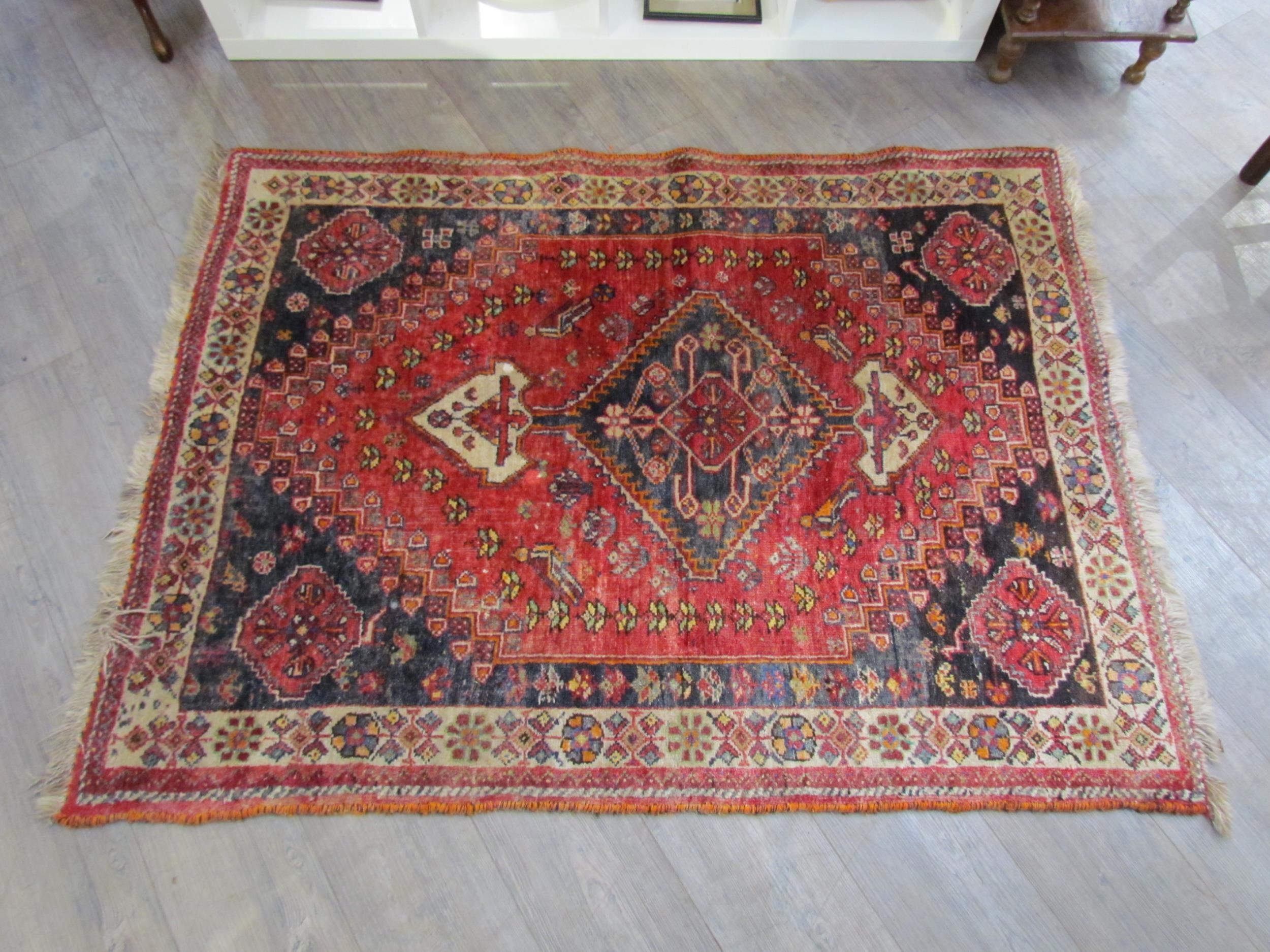 A Persian hand knotted wool rug, red ground with birds and floral borders, 155cm x 115cm