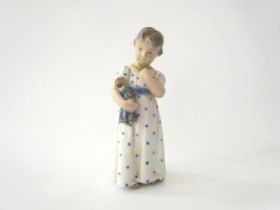 A Royal Copenhagen figure of child holding a doll, 15cm tall