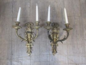 A pair of cast gilded twin branch candle wall lights with ribbon and acanthus detail, 36cm tall