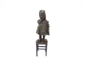 JUAN CLARA AYATS (1875-1958): A bronze sculpture of young girl standing on a rush seated stool,