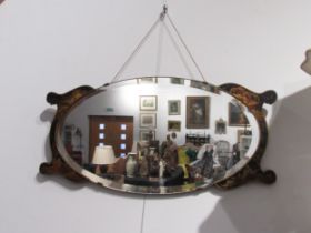 An oval bevel edge wall mirror with chinoiserie flanked ends, 78cm long