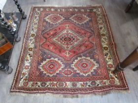 A Middle Eastern wool rug, central lozenge, dark pink ground, multiple borders, 143cm x 128cm