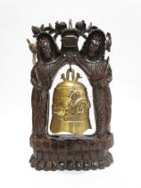 An Oriental carved hardwood and brass bell, 45cm high