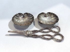 A pair of silver grape scissors with branch effect handles and two white metal scallop form