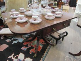 A Regency mahogany drop flap library centre table with one true drawer, ring turned column to