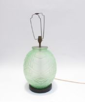 An Art Deco green glass lamp of bulbous form on carved wood base