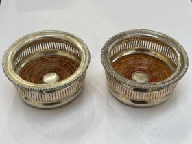 A pair of Asprey of London silver and turned hardwood wine glass coasters, gadrooned edge, pierced
