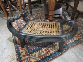A Regency ebony scroll arm stool with cane work seat with melon fluted turned detail, 29cm x 49cm