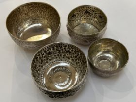 Four Indian silver engraved and embossed bowls varying sizes decorated with flowers and elephants,
