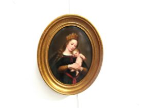 A gilt framed Berlin Porcelain oval plaque painted with a portrait of the Madonna and Child.