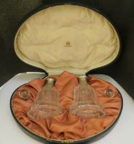 A pair of etched glass bottles with guilloche band in deep amber, glass stoppers, within a fitted