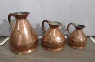 A Victorian copper four gallon jug, two gallon jug and a one gallon jug (dented), 42cm, 29cm &