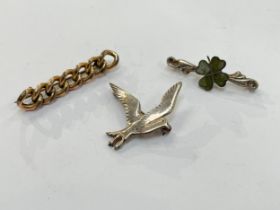 A silver dove brooch, silver four leaf clover brooch and pinchbeck brooch (3)