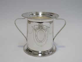 A silver plated ice bucket with twin handles, ribbon and swag detail, 16cm tall