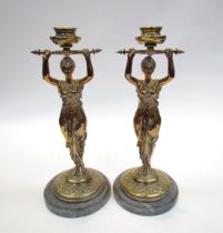 A pair of brass candlesticks as robe clad females, upon grey marble plinth bases, 30cm high
