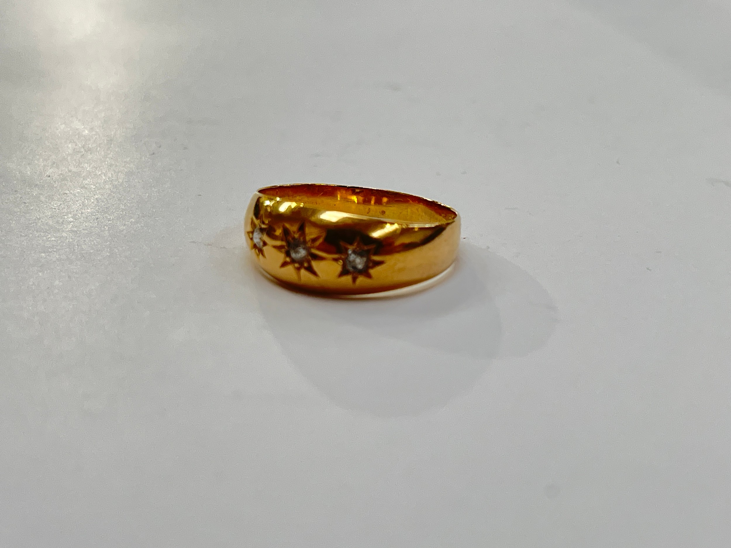 An 18ct gold gypsy ring set with three old cut diamonds, star setting. Size O, 2g - Image 2 of 2