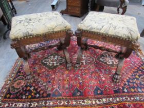 A pair of Victorian Gothic style oak stools, mythical creature mounts to stretcher base and lions