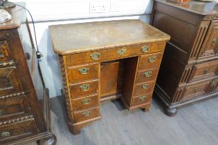 An 18th Century walnut kneehole desk, canted corner top over nine drawer and single door cabinet,
