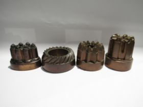Four 19th Century copper jelly moulds. Three cast iron form, all varying in size. Three have