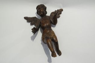 A 19th Century fruitwood angel figure, damage to fingers, 35.5cm tall, 27.5cm wide, 16cm deep