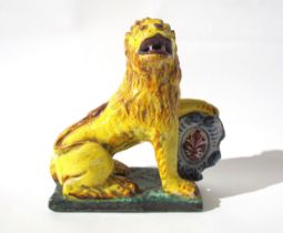 A 19th Century Italian faience figure of a lion with heraldic crest, 23cm high