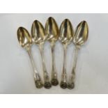 Four Georgian silver king's hourglass pattern serving spoons and another Victorian spoon, all
