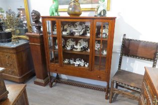 In the manner of "Sir Ambrose Heal" An Arts & Crafts inlaid oak single door (with key) bookcase/