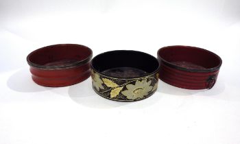 Three Regency papier-mache wine bottle coasters circa 1820, two red one black decorated with