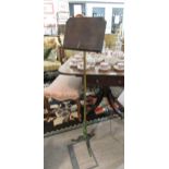 A Robertson and Colman Norwich cast tripod based music stand with brass pole, adjustable angle