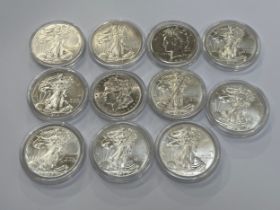 Nine 1oz fine silver American one dollar coins including 2013 Eagle