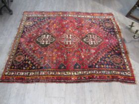 A Persian silk and wool hand knotted rug, three central guls, red ground, multiple borders, 145cm
