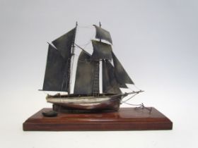 A silver model of a sailing vessel, hallmark indistinct, 22cm tall, on plinth base