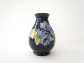 A Moorcroft Hibiscus pattern vase in pale blue with dark blue ground, 14cm tall