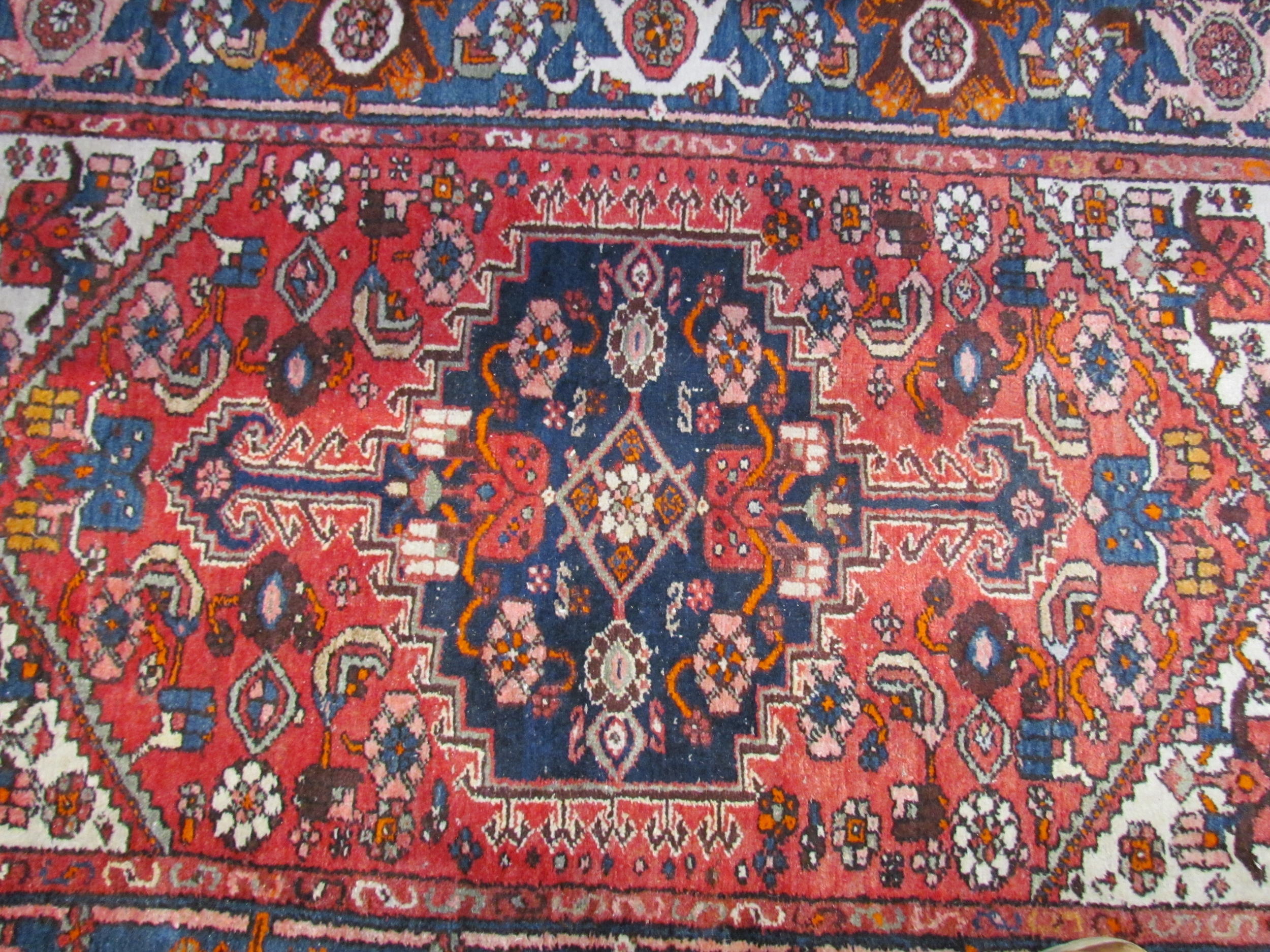 A Persian hand knotted rug, red ground with navy foliate border, 200cm x 132cm - Image 3 of 5
