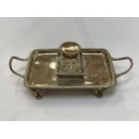 An Edwardian silver desk stand, twin handle, gadrooned border, central inkwell, raised on feet,