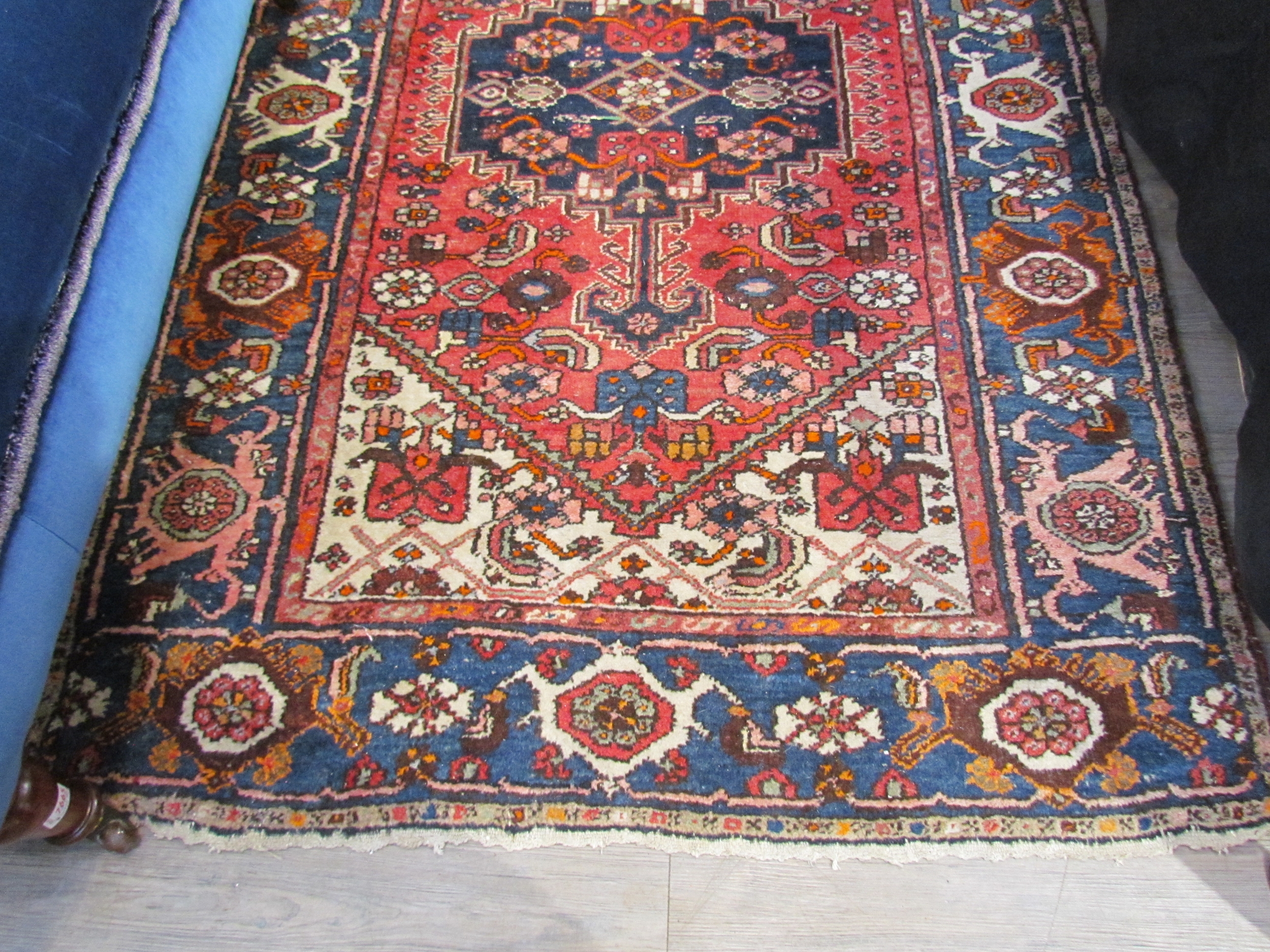 A Persian hand knotted rug, red ground with navy foliate border, 200cm x 132cm - Image 2 of 5