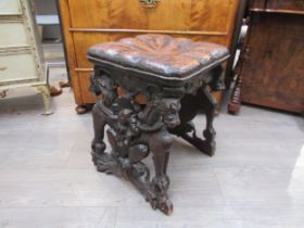 A 19th Century walnut stool carved with lions