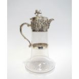 A Hukin & Heath silver plated glass carafe with border of cherubs and putti playing, lion and shield