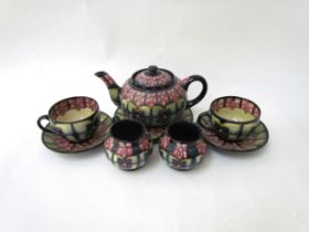 A Moorcroft Violet pattern tea service for two