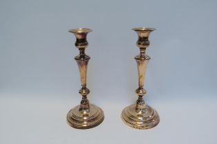 A pair of copper candlesticks on circular bases, 29cm tall