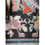 A hand-woven black ground carpet, 325cm x 240cm