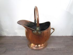 A Victorian copper helmet form coal scuttle